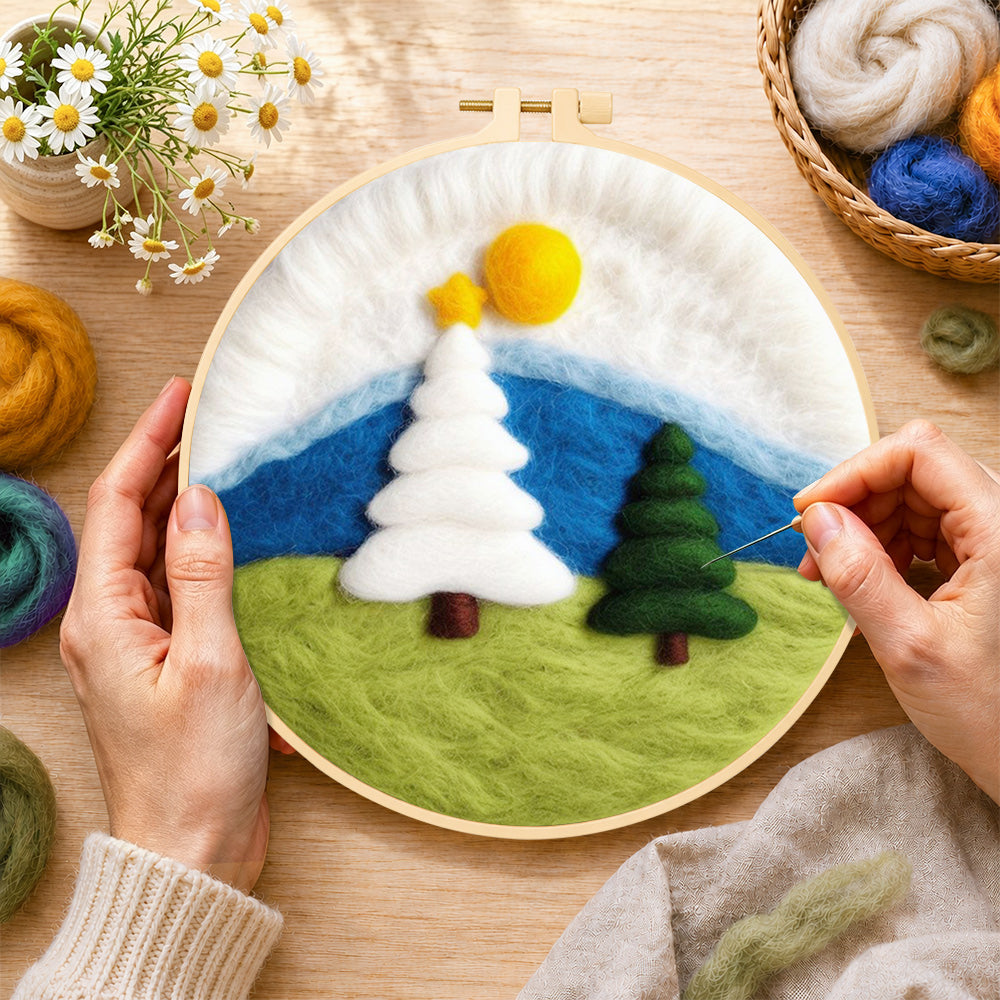 Creating the white and green christmas trees on grass wool painting by hand with a felting needle