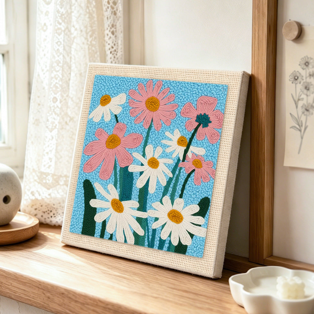 White and pink daisies punch needle artwork displayed on a table