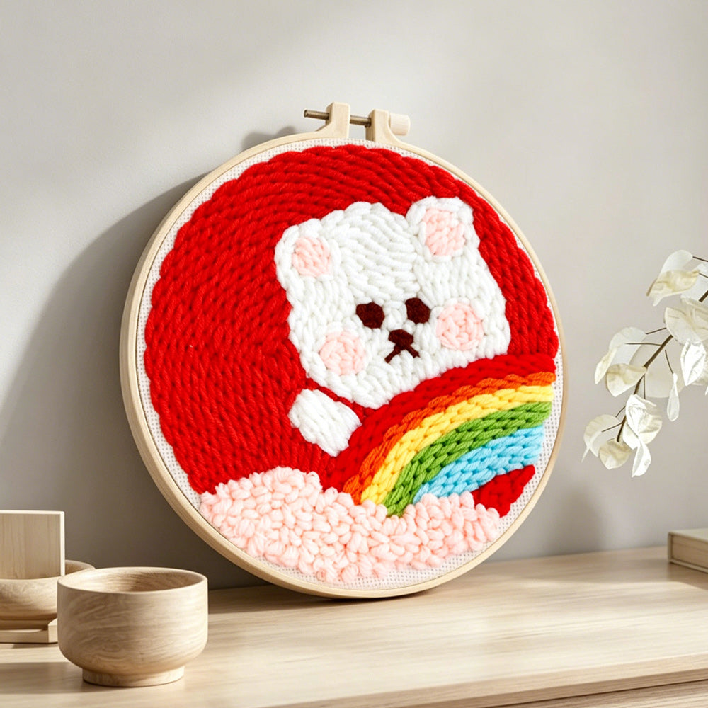 White bear with rainbow punch needle artwork displayed on a table