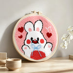 White bunny with hearts punch needle artwork displayed on a table