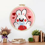 Finished white bunny with hearts artwork displayed on a wall
