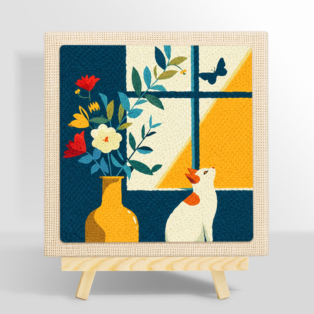 White cat looking at a butterfly punch needle kit for beginners