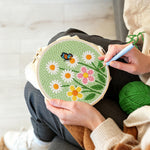 Creating handmade white daisies and butterfly punch needle artwork