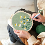 Creating handmade white daisies on mint green background punch needle artwork