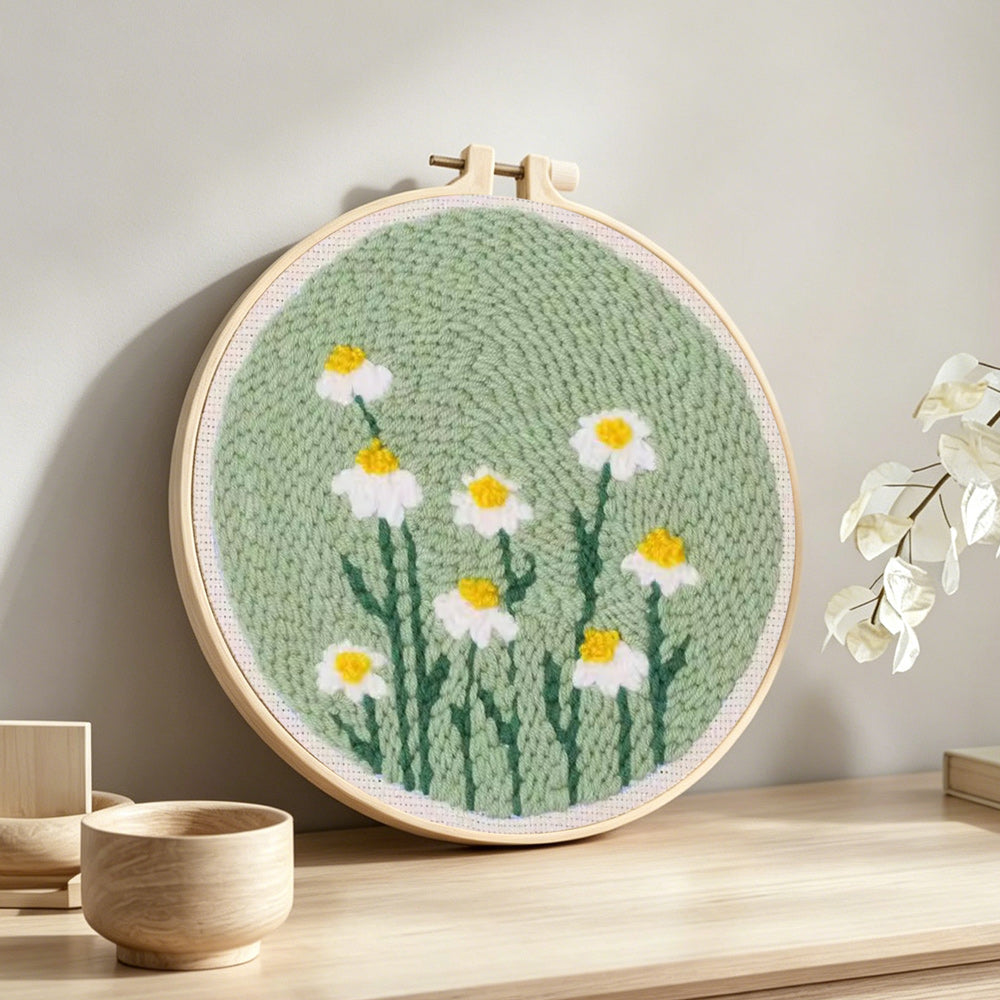 White daisies on mint green background punch needle artwork displayed on a table
