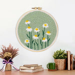 Finished white daisies on mint green background artwork displayed on a wall