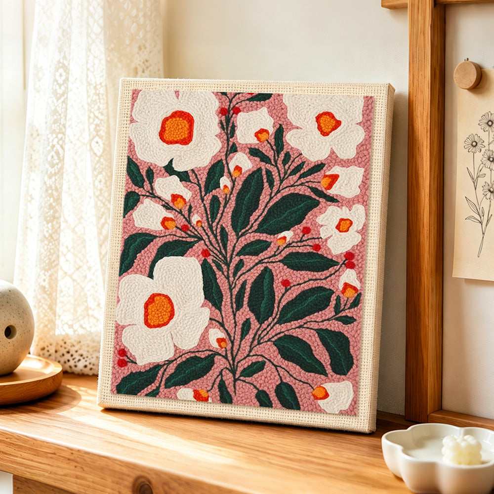 White florals on dusty pink background punch needle artwork displayed on a table