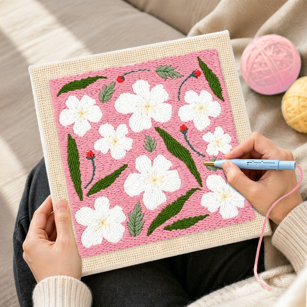 Creating handmade white flowers with green leaves punch needle artwork
