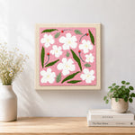 Finished white flowers with green leaves artwork displayed on a wall