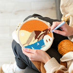 Creating handmade white house by blue sea under orange sky punch needle artwork