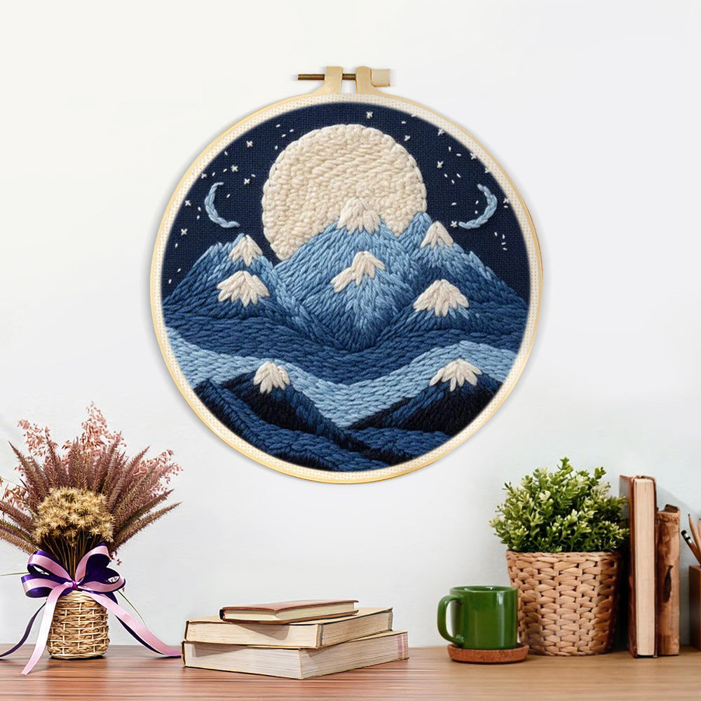 Finished white moon above blue snowy mountains artwork displayed on a wall