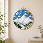 White mountain peaks under the blue sky needle felt wall art displayed in a bright home interior