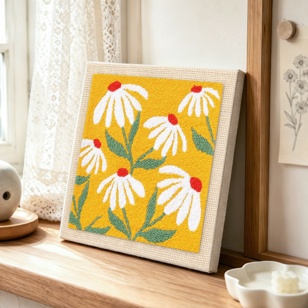 White petals with red centres punch needle artwork displayed on a table