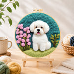 Finished white puppy with pink flowers needle felting displayed on a wooden easel