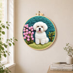 White puppy with pink flowers needle felt wall art displayed in a bright home interior