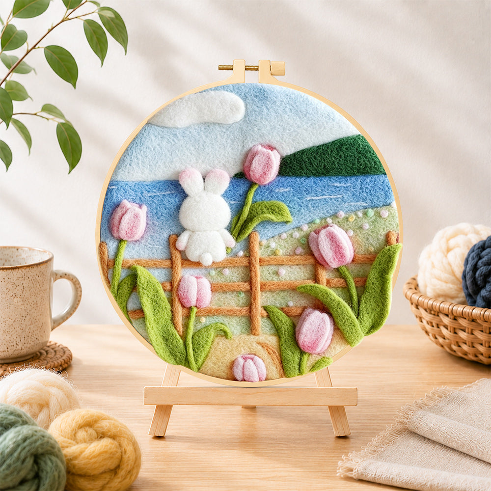 Finished white rabbit on fence with tulips needle felting displayed on a wooden easel