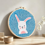 White rabbit with upright ears punch needle artwork displayed on a table