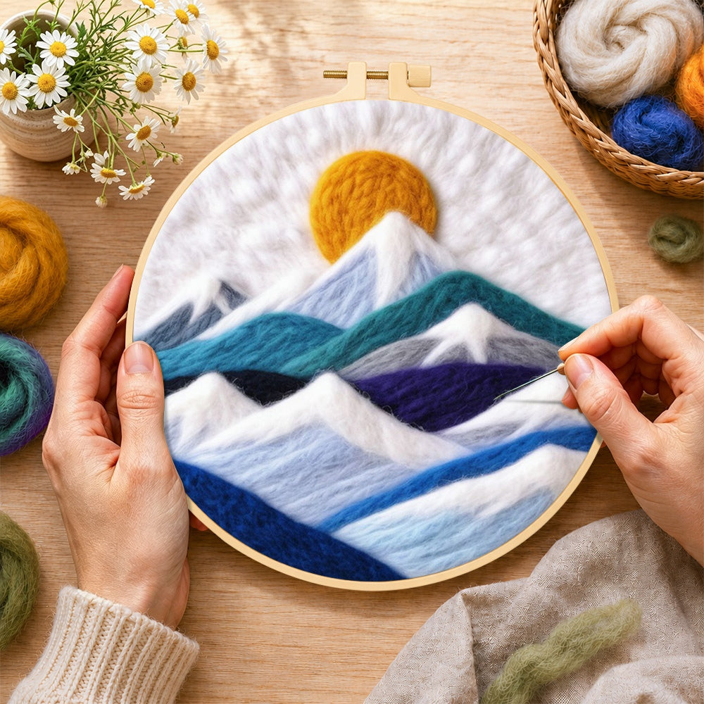 Creating the white snow mountains and golden spiral sun wool painting by hand with a felting needle