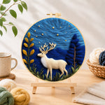 Finished white strolling deer needle felting displayed on a wooden easel