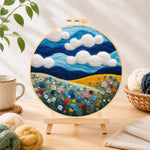 Finished wildflowers under the vibrant blue sky needle felting displayed on a wooden easel