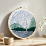 Windmill in mountain landscape punch needle artwork displayed on a table