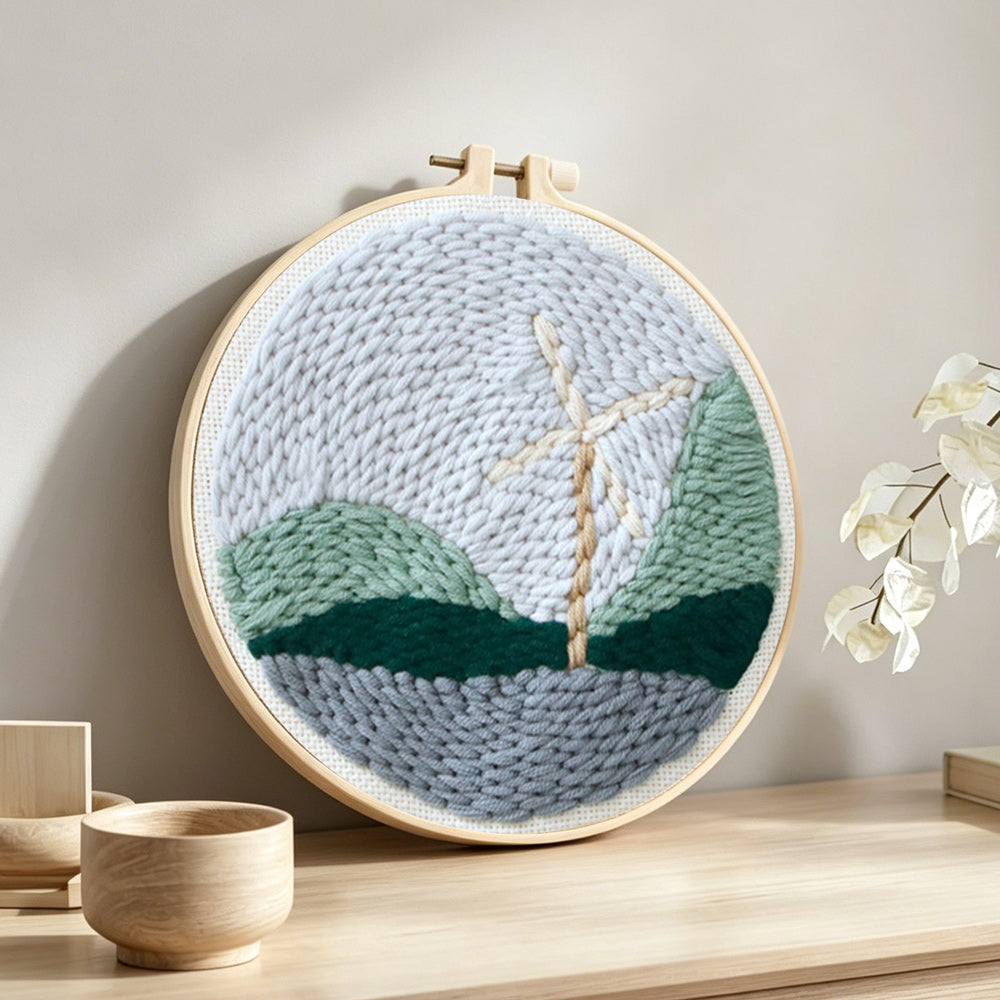 Windmill in mountain landscape punch needle artwork displayed on a table