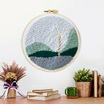 Finished windmill in mountain landscape artwork displayed on a wall