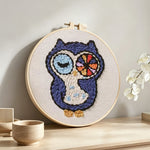 Winking owl punch needle artwork displayed on a table
