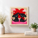 Finished winter black puppies with red heart artwork displayed on a wall