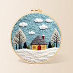 Winter cabin and snow-covered trees needle felting kit for beginners with a round wooden frame