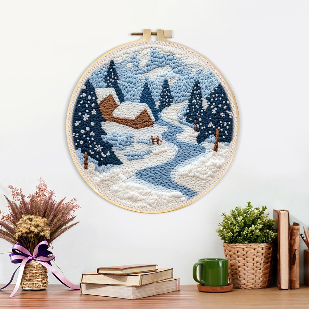 Finished winter cabin scene with snowy pine trees and blue river artwork displayed on a wall
