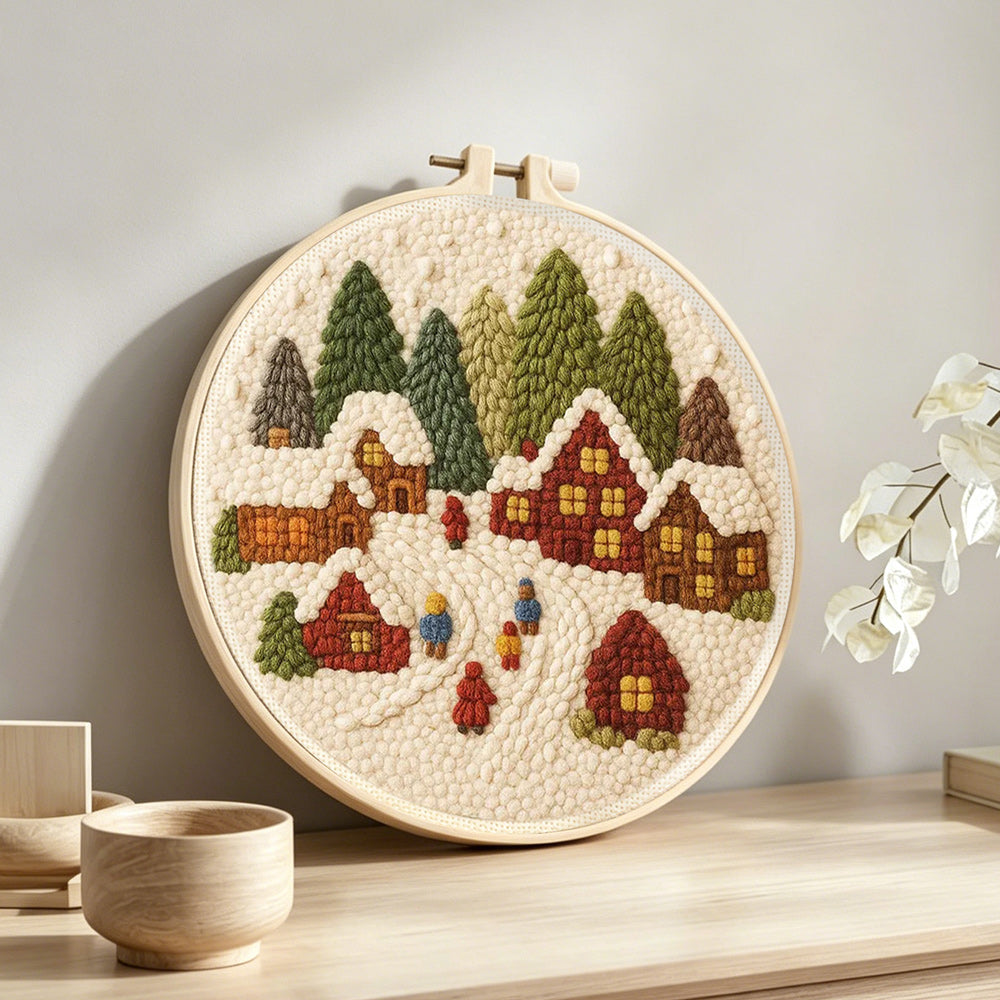 Winter wonderland village punch needle artwork displayed on a table