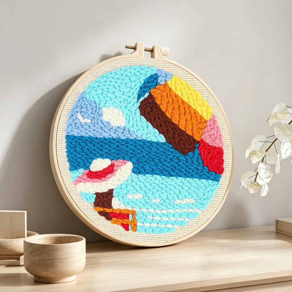 Woman on vacation at seaside punch needle artwork displayed on a table