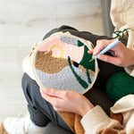 Creating handmade woman wearing gold earrings punch needle artwork