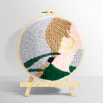 Woman wearing gold earrings punch needle kit for beginners