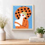 Finished woman with red lips in orange artwork displayed on a wall