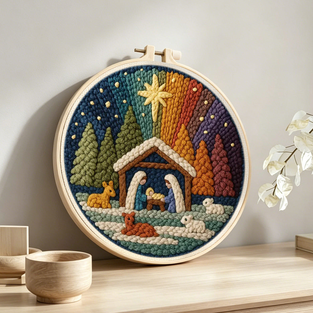 Wooden stable, figures and animals in a forest punch needle artwork displayed on a table