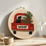 "Woof" red truck with dog punch needle artwork displayed on a table