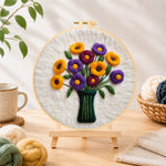 Finished yellow and purple flowers in vase needle felting displayed on a wooden easel
