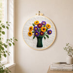 Yellow and purple flowers in vase needle felt wall art displayed in a bright home interior