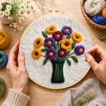 Creating the yellow and purple flowers in vase wool painting by hand with a felting needle