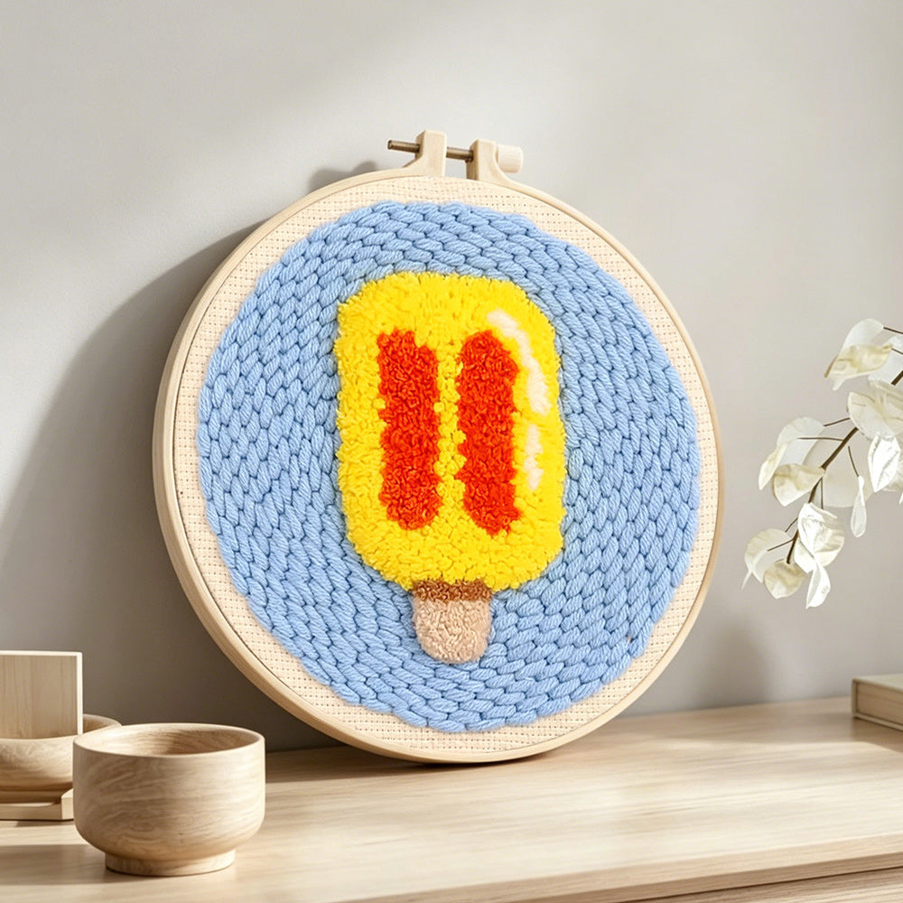 Yellow and red ice lolly punch needle artwork displayed on a table