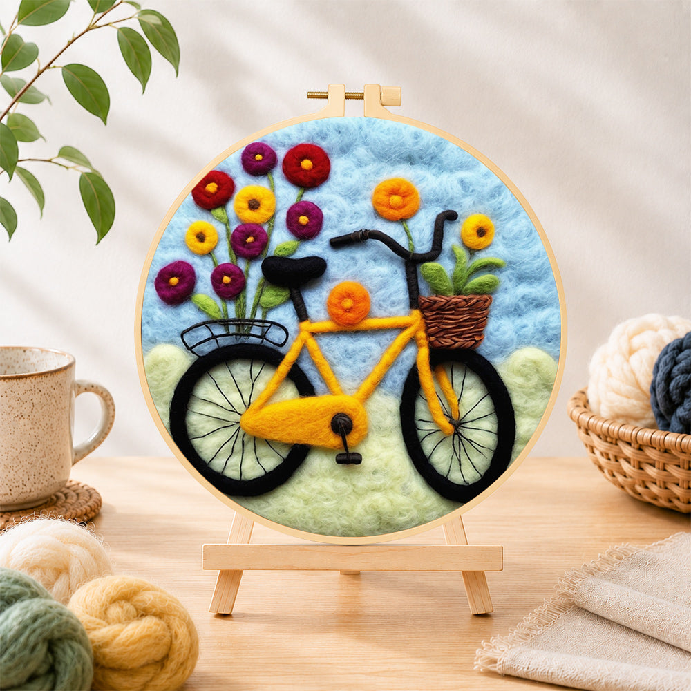 Finished yellow bicycle with flowers needle felting displayed on a wooden easel