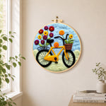 Yellow bicycle with flowers needle felt wall art displayed in a bright home interior