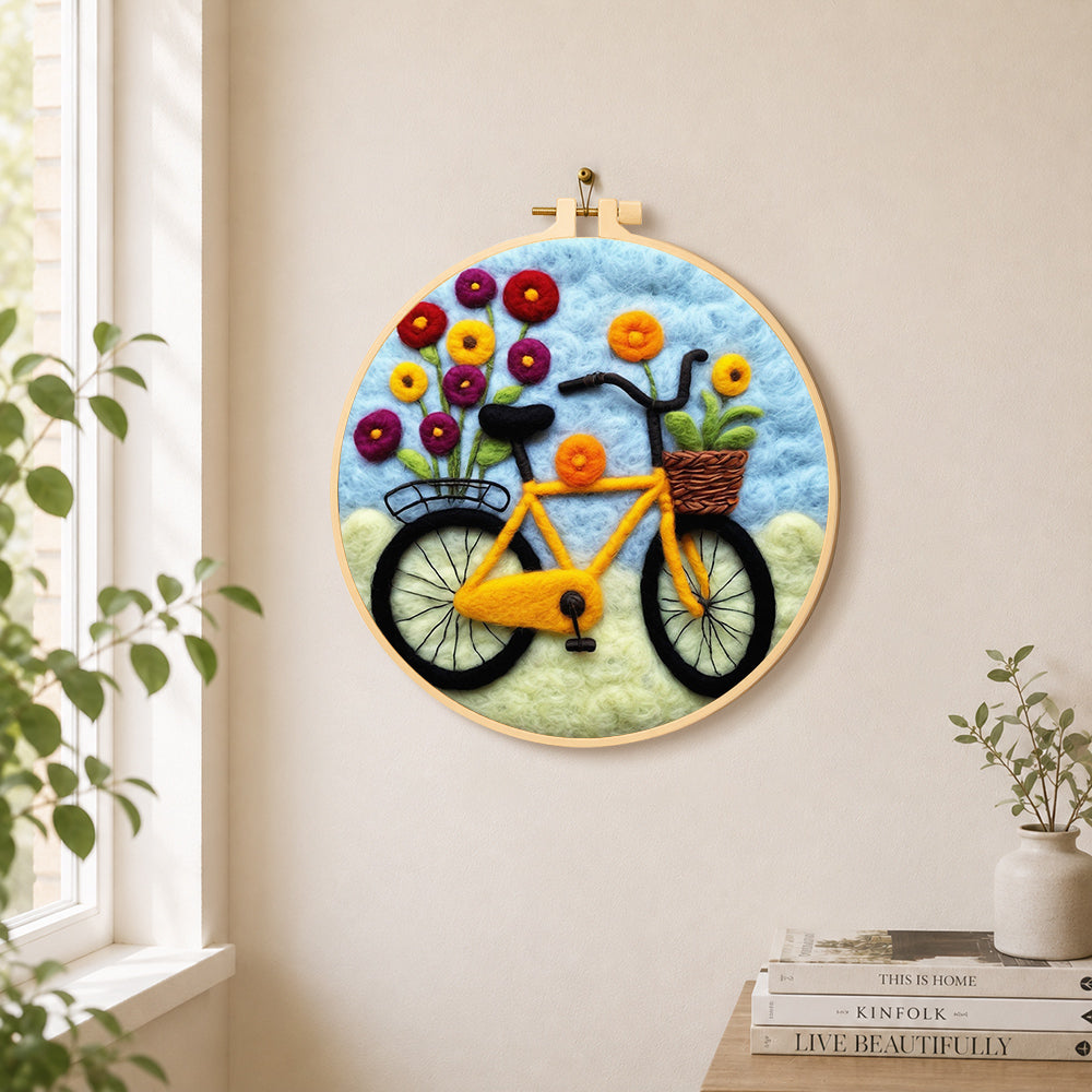 Yellow bicycle with flowers needle felt wall art displayed in a bright home interior