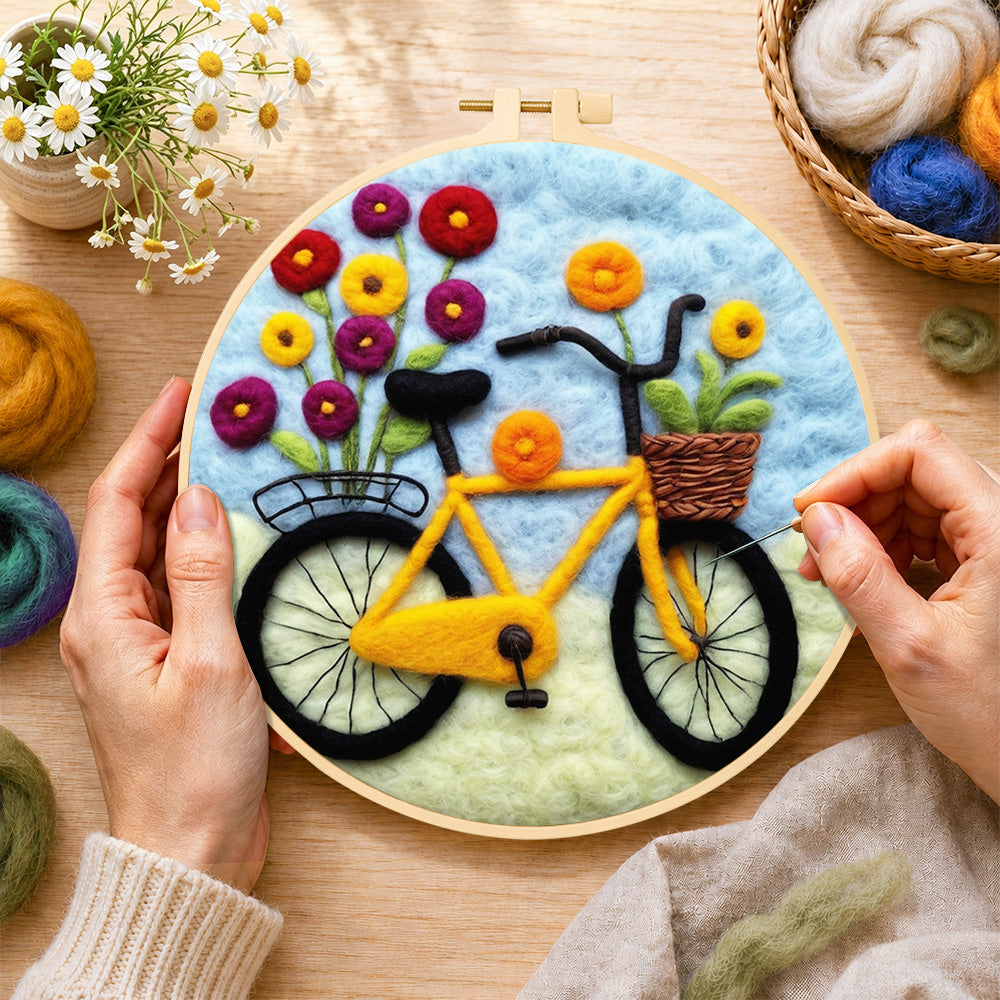 Creating the yellow bicycle with flowers wool painting by hand with a felting needle