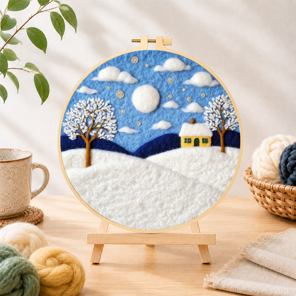 Finished yellow cottage in the snow needle felting displayed on a wooden easel