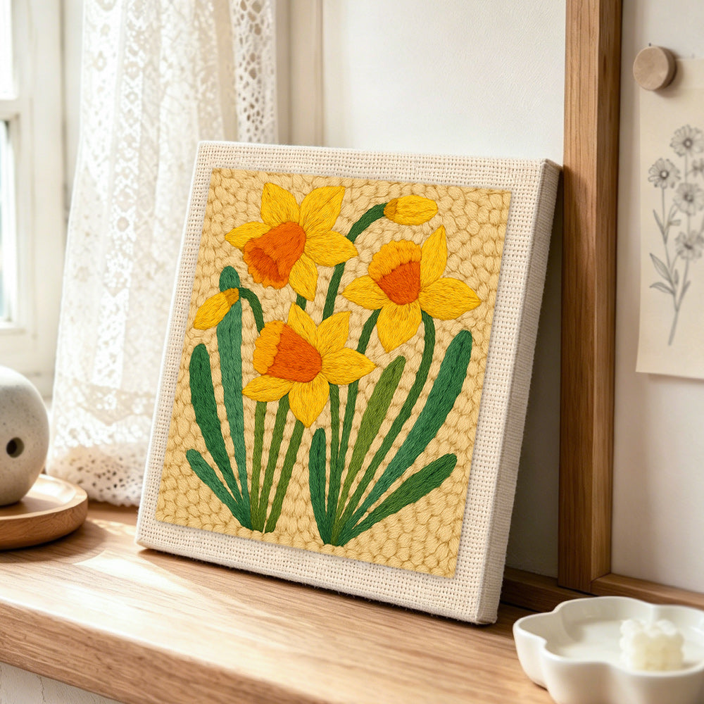Yellow daffodils punch needle artwork displayed on a table