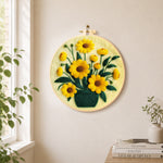 Yellow daisies in dark green vase needle felt wall art displayed in a bright home interior