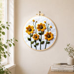Yellow daisies with green stamens needle felt wall art displayed in a bright home interior